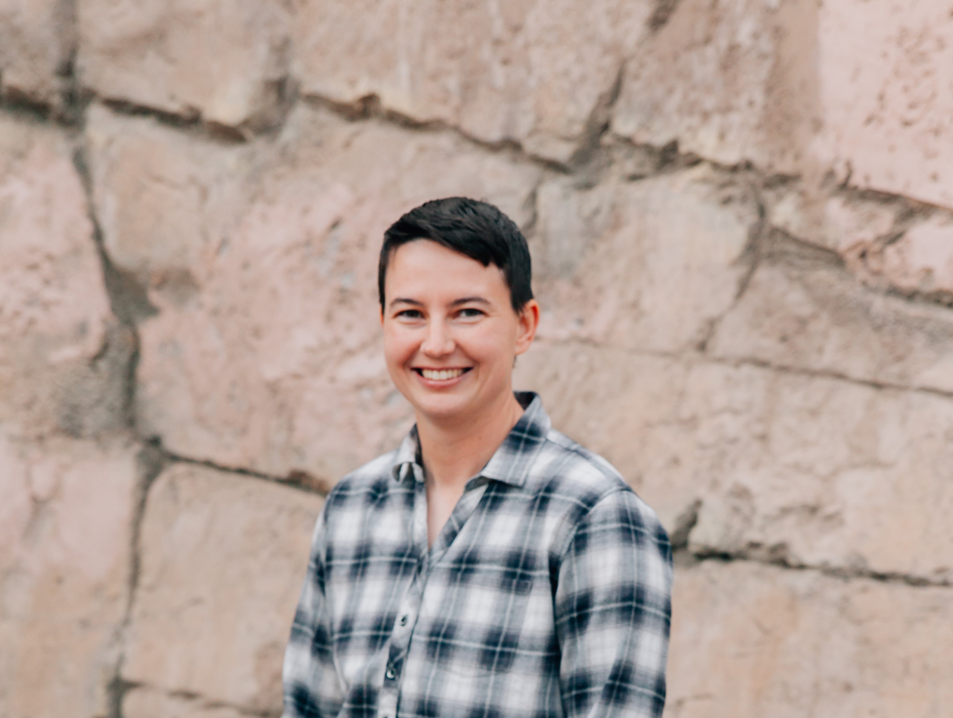 Headshot of EJ in front of a stone background.